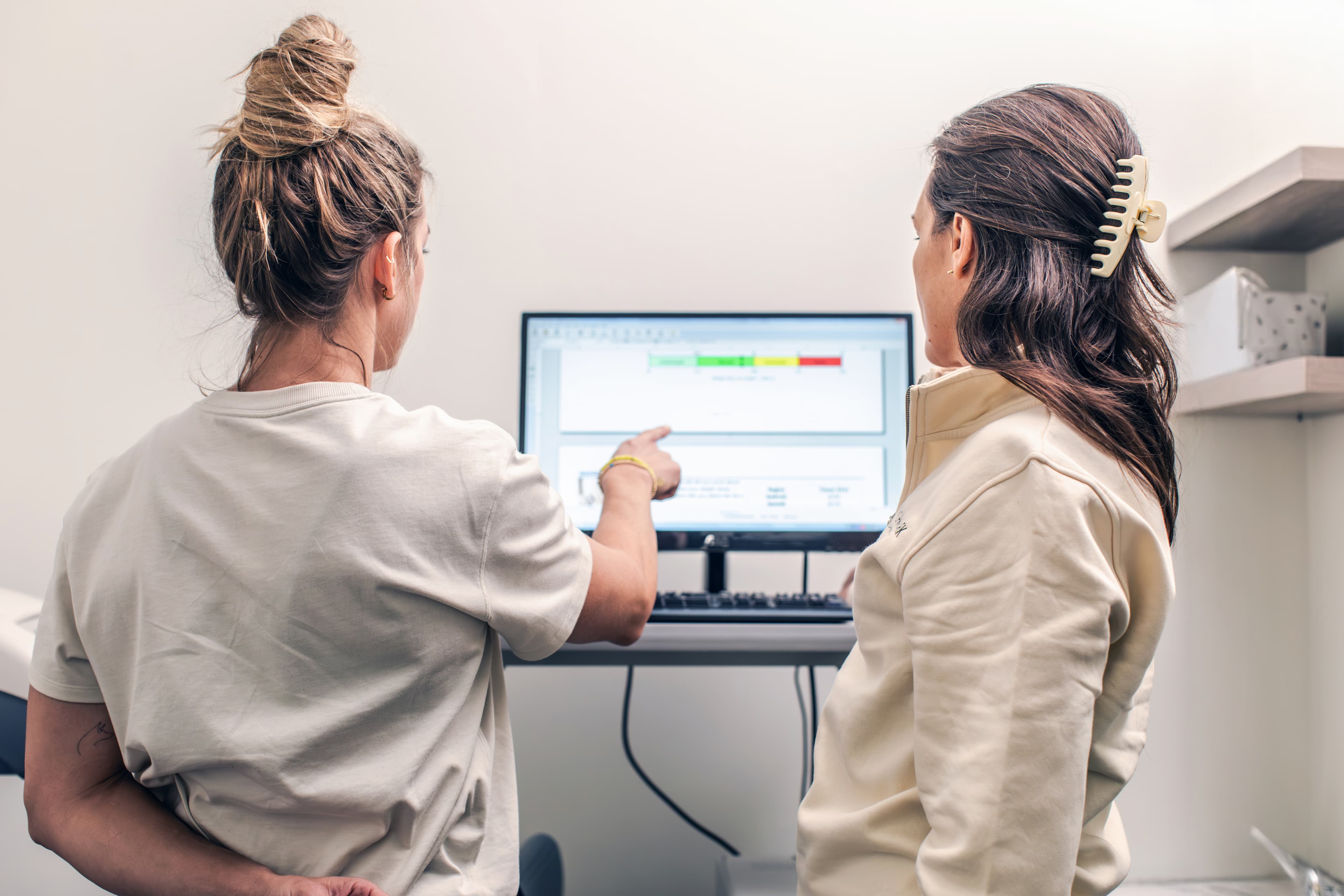 Clinician reviewing DEXA results with a patient on a computer screen