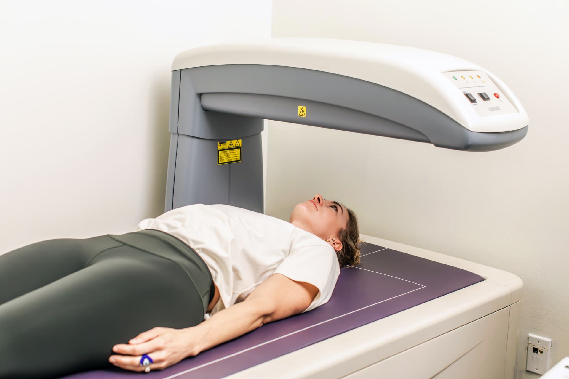 Person lying on a DEXA scanner during a body composition scan at Benchmark Proactive Health in Burlington