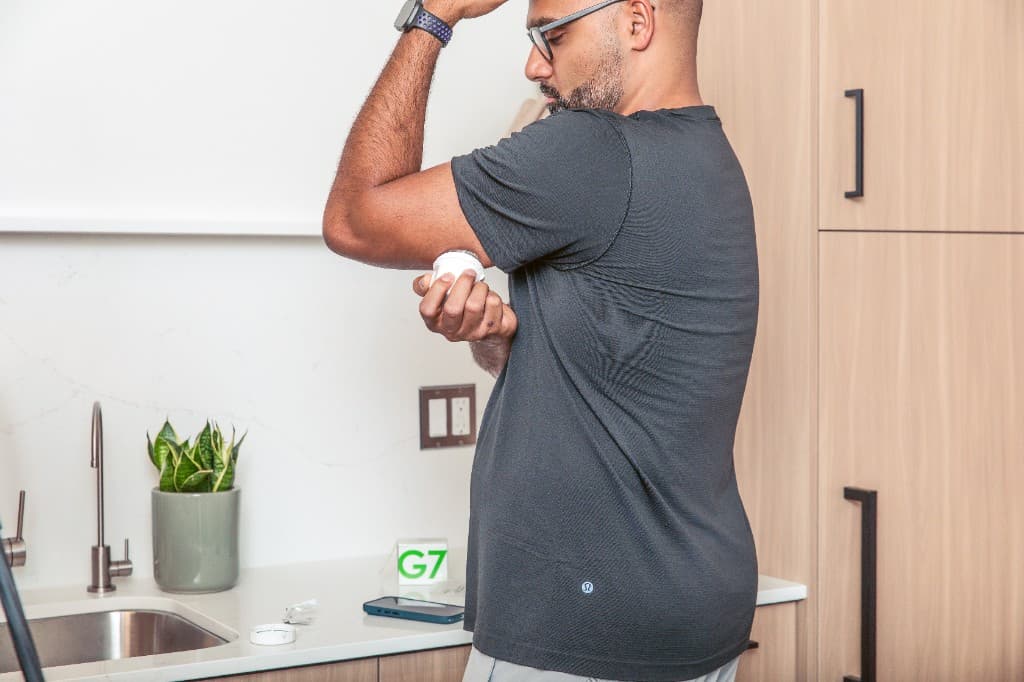 Member applying a Dexcom G7 continuous glucose monitor at home