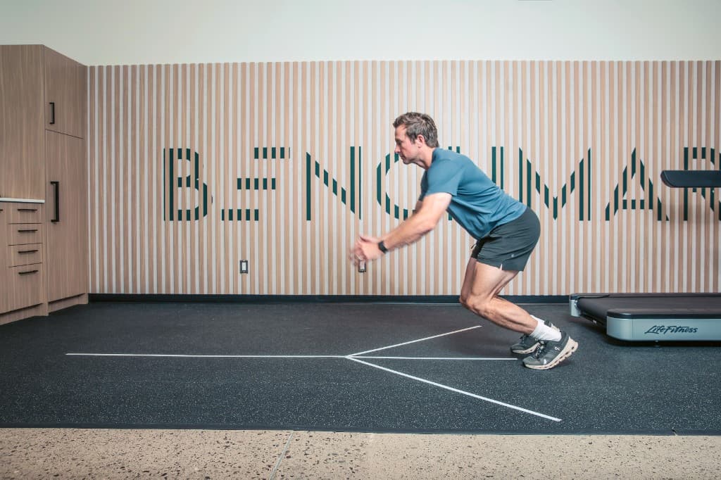 Member completing a functional movement test on the assessment floor