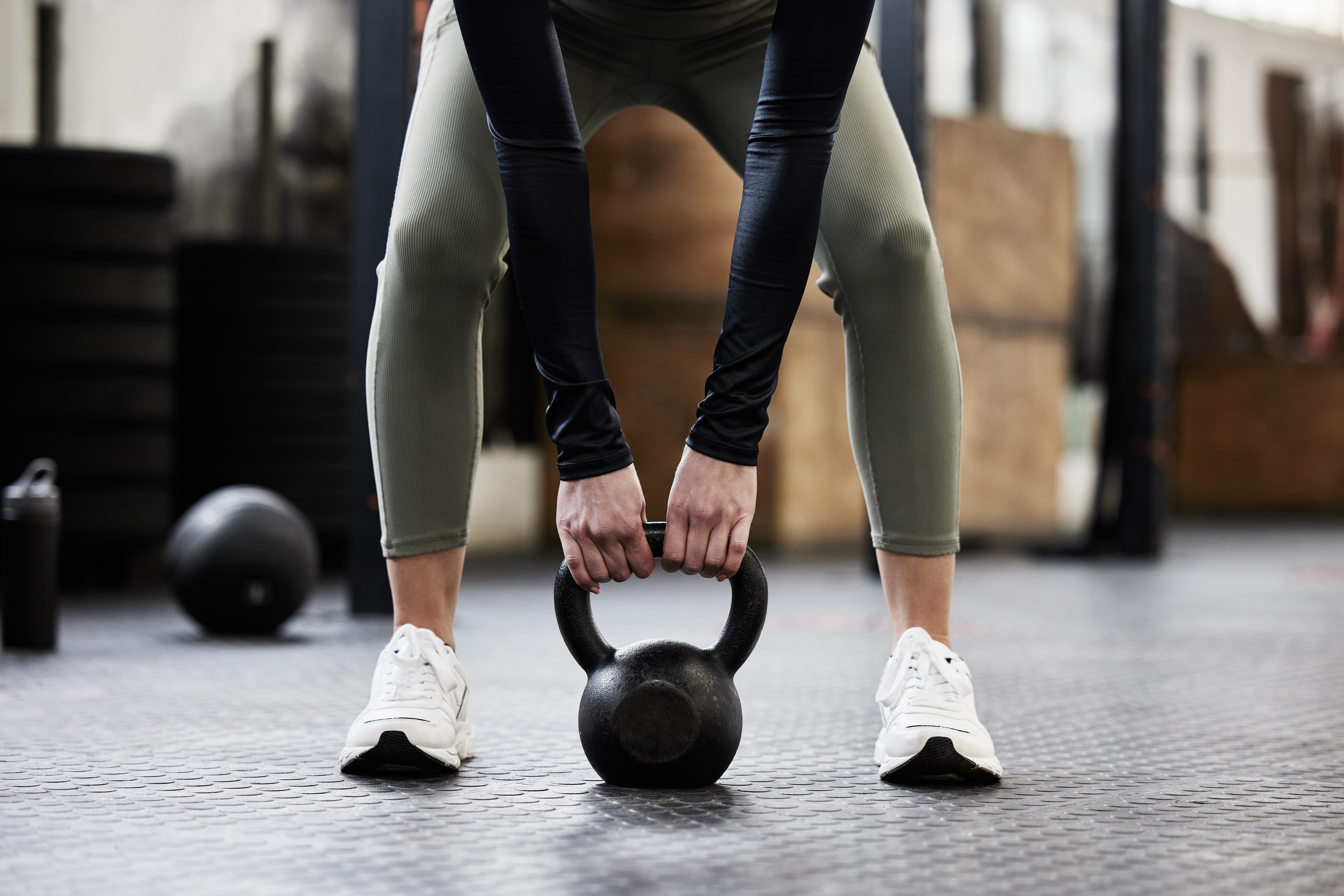 Person lifting a kettlebell in a gym